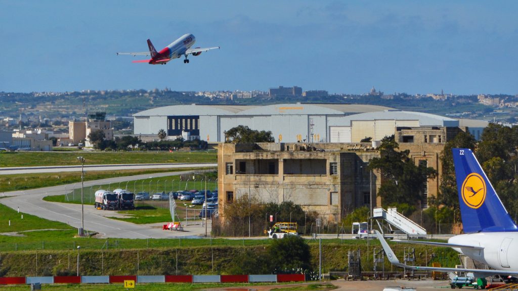 Ein Flugzeug der Fluggesellschaft Air Malta hebt in Richtung der Lufthansa Technik Malta Hangars ab.